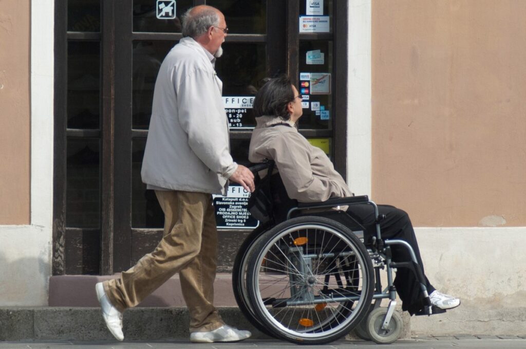 Familiare spinge una carrozzina per disabile