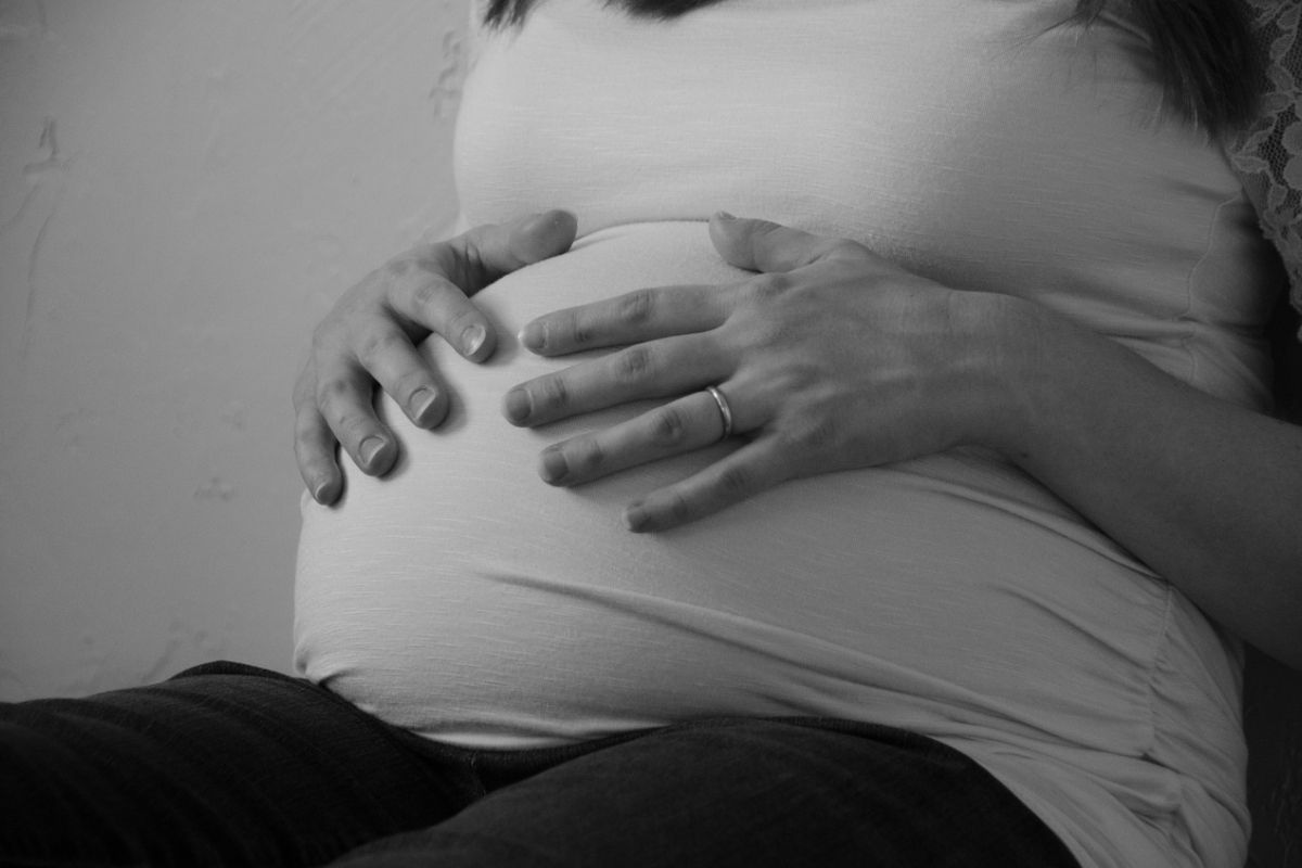 Gravidanza, una donna incinta con le mani sulla pancia