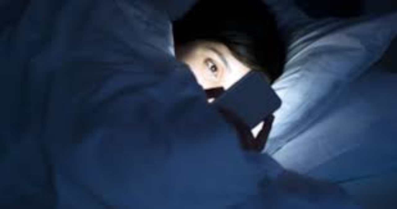 bambino a letto con il cellulare