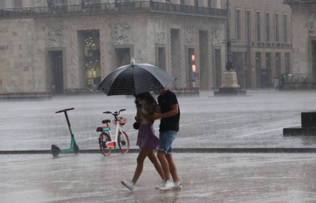 coppia di ragazzi sotto l'ombrello si riparano dalla pioggia