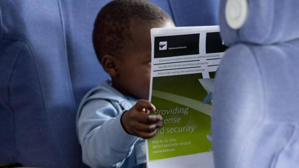 bambino con un giornale su un aereo