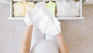 Donna in maternità che ordina gli abitini da bambino