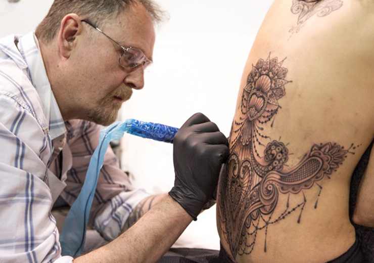 Marco Manzo tra i migliori tatuatori a Roma, tatua la schiena di una modella