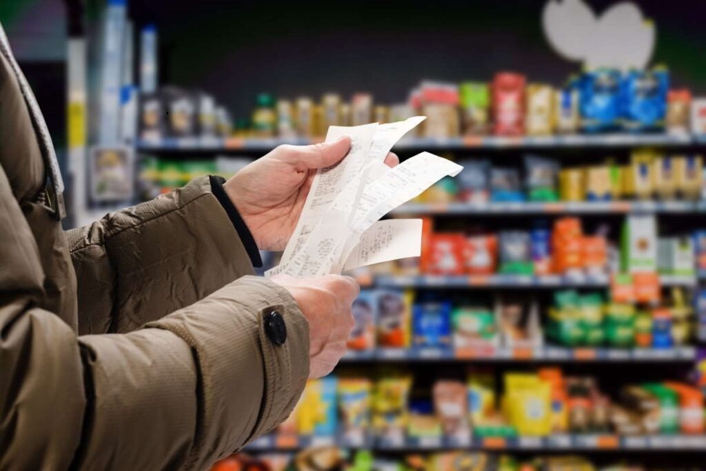 Una donna al supermercato con la lista della spesa