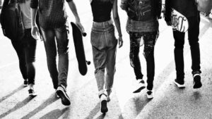 Gambe di adolescenti in bianco e nero mentre camminano