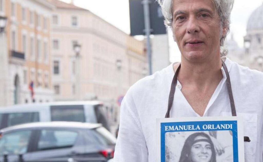 Pietro Orlandi con manifesto Emanuela e sfondo San Pietro