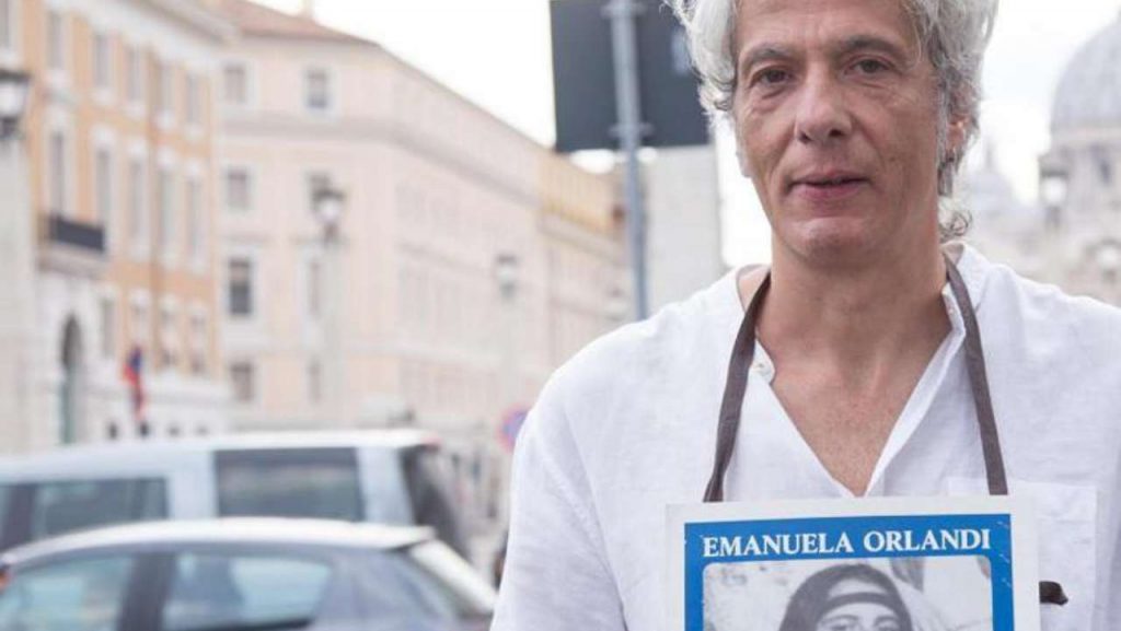 Pietro Orlandi con manifesto Emanuela e sfondo San Pietro