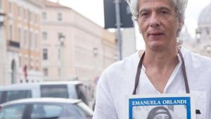 Pietro Orlandi con manifesto Emanuela e sfondo San Pietro