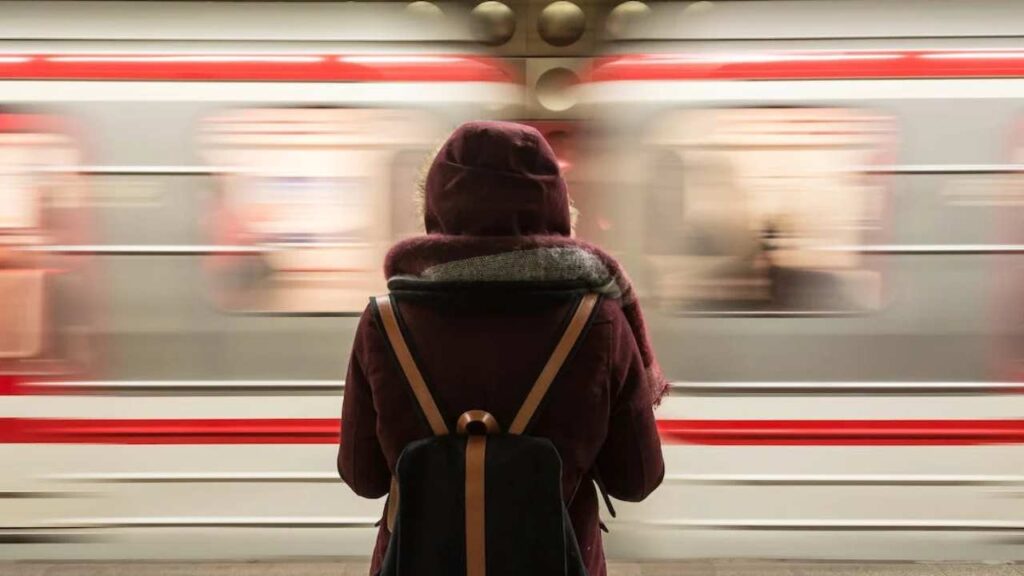 Una ragazza pendolare attende il treno