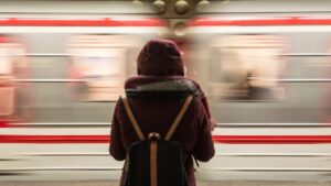 Una ragazza pendolare attende il treno