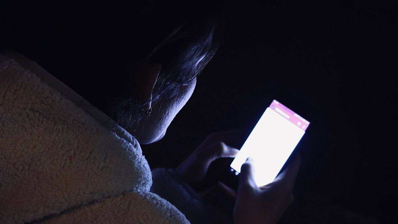 Una donna usa il telefono di notte