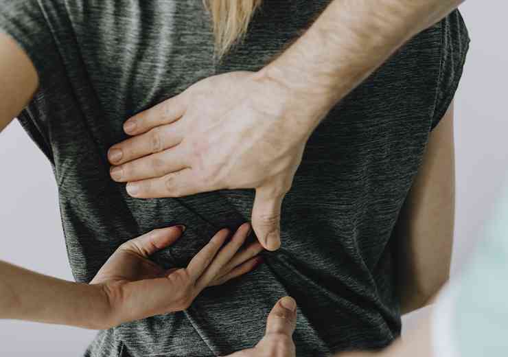 Tecnica di osteopatia su schiena donna, studio di Valerio Cela a Roma