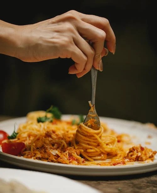 Un piatto di spaghetti al ristorante mangiati da una ragazza
