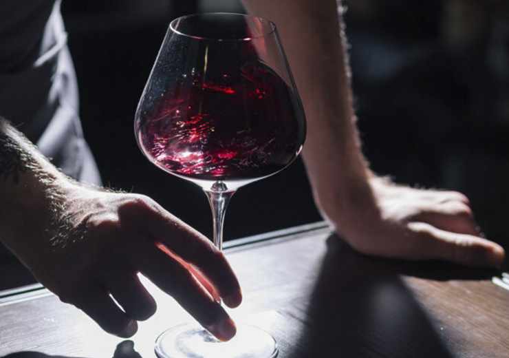 Calice di vino rosso mani maschili