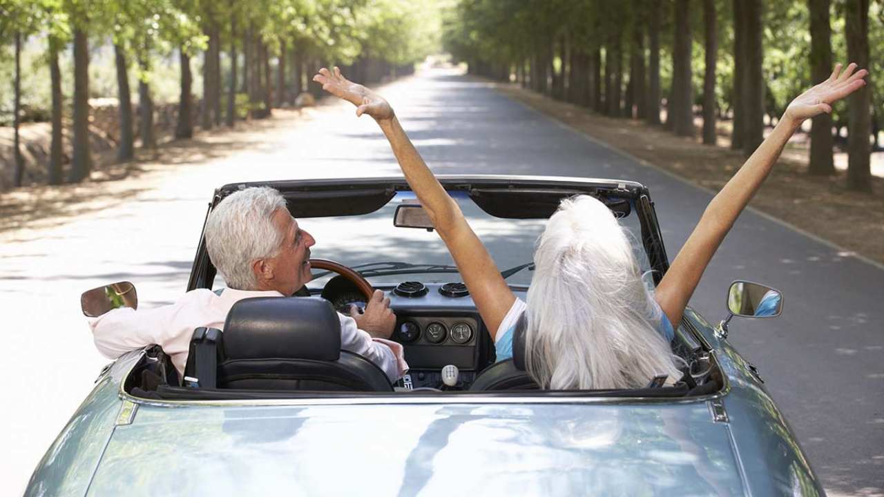 Due anziani di spalle in automobile felici