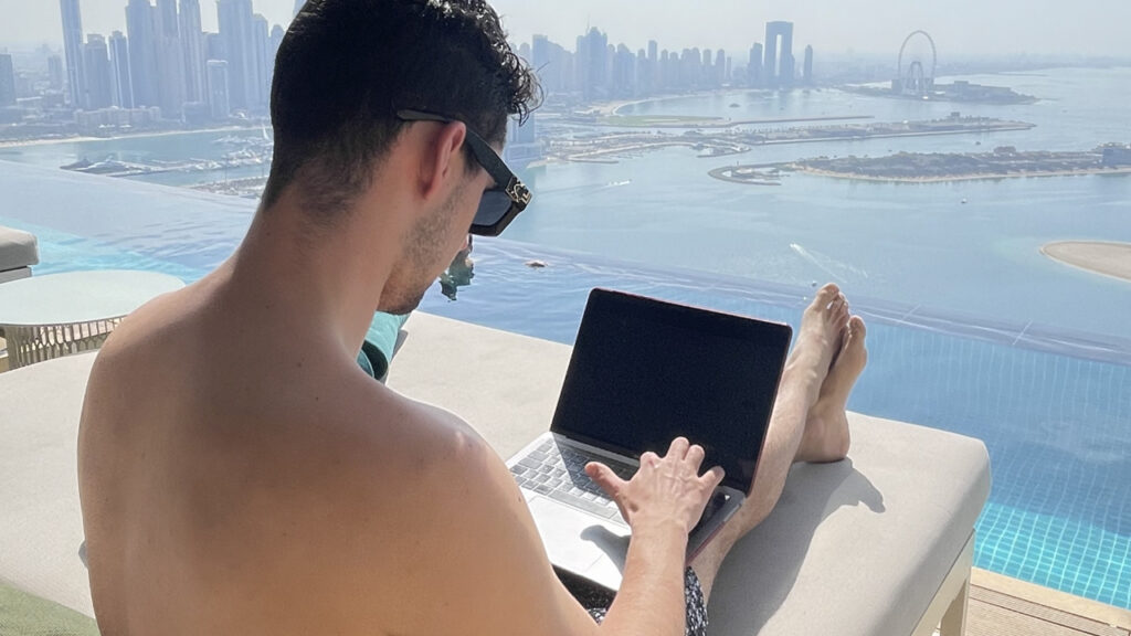 Antony Rossi al pc desktop portatile in piscina con panorama