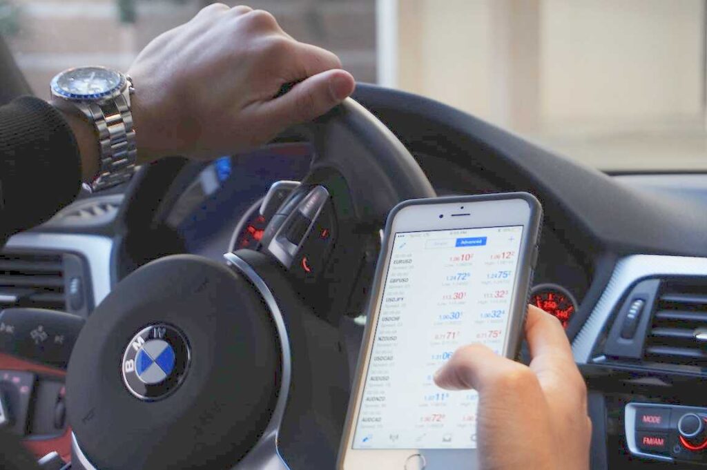 Guida di automobile con il cellulare in mano