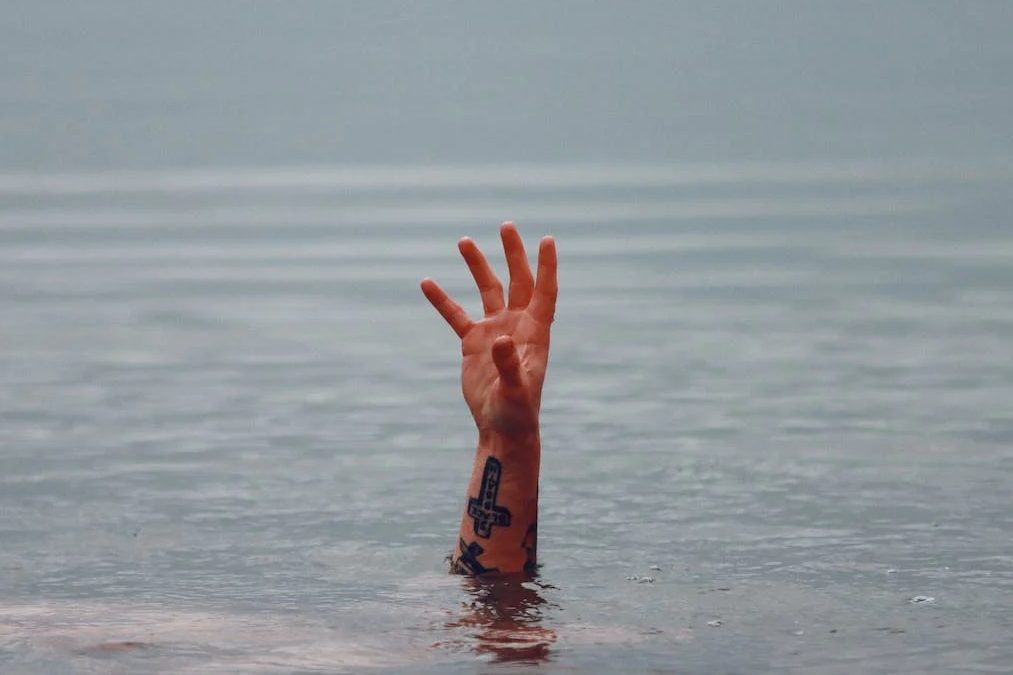Una persona che sta annegando e mostra la mano