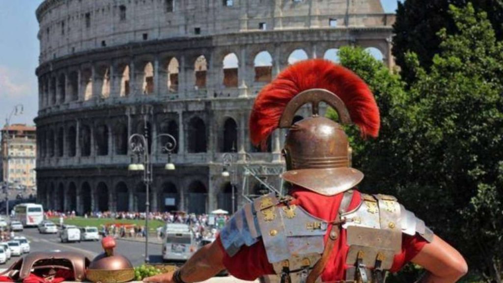Uomo vestito da soldato romano davanti il Colosseo di Roma