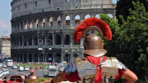 Uomo vestito da soldato romano davanti il Colosseo di Roma